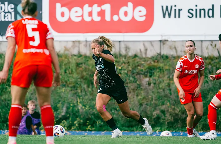 Foto: Una persona con un casco de fútbol y un balón en las manos desde atrás.