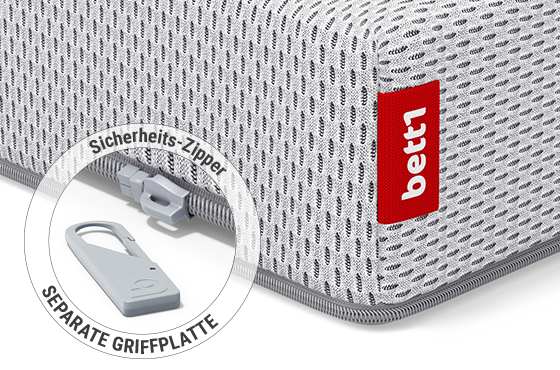 Eine Ecke der SuperBreeze Kindermatratze: Zoom auf den Reißverschluss mit abgenommener Griffplatte. Text: Sicherheits-Zipper/separate Griffplatte	