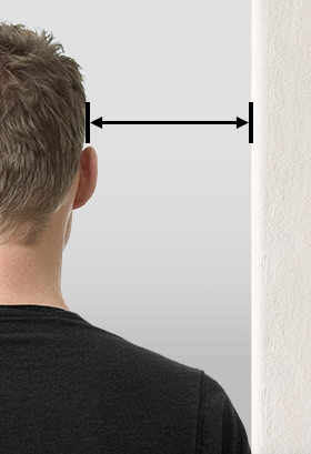 Hombre de perfil midiendo la distancia entre la cabeza y la pared.