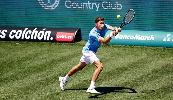 Imagen de un jugador de tenis durante el torneo Mallorca Championship, con el logotipo de bett1.es visible como sponsor en el fondo.