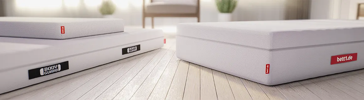 Gráfico que muestra las dimensiones de diferentes colchones Bodyguard junto a figuras de mujer y hombre para comparar tamaños.