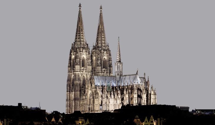 Foto: Der Kölner Dom angestrahlt über der dunklen Stadt.
