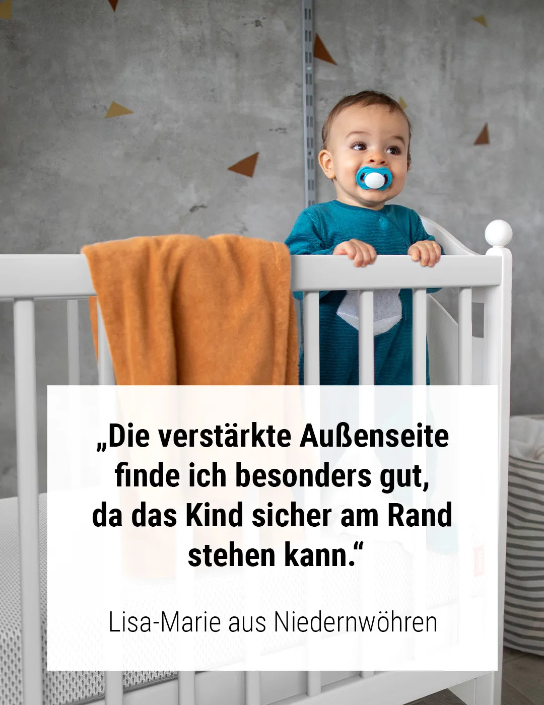 Baby steht in Gitterbett auf der BODYGUARD® Kindermatratze. Text: „Die verstärkte Außenseite finde ich besonders gut, da das Kind sicher am Rand stehen kann.“ Lisa-Marie aus Niedernwöhren	