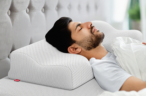 Hombre acostado de lado usando la almohada BODYGUARD.