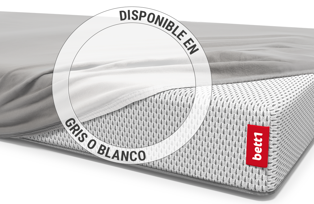 El colchón infantil BODYGUARD® está cubierto hasta una esquina con una sábana ajustable para niños en color plateado. Zoom en la sábana en la variante de color blanco. Texto: Disponible en plata o blanco.