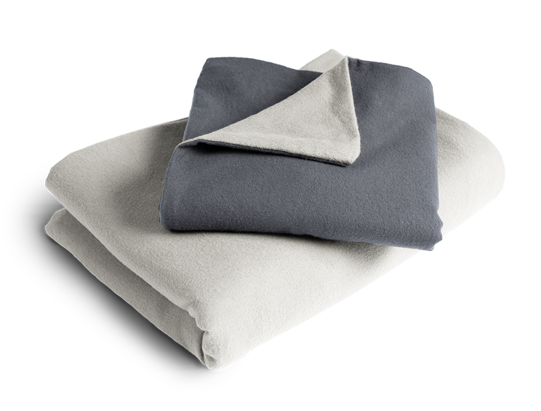 La ropa de cama de franela BODYGUARD® doblada: la funda de edredón está plegada con el lado plateado hacia afuera, y la funda de almohada con el lado color antracita.