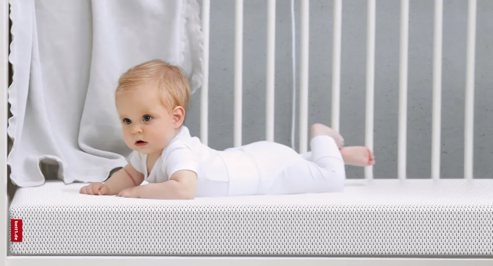 Baby liegt auf einer Kindermatratze