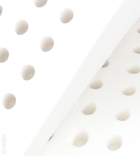 Sección de dos núcleos de colchón blancos, colocados uno sobre el otro, con perforaciones redondas.