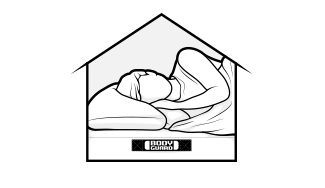 Eine auf einer Matratze schlafende Person in einem Haus-Umriss.