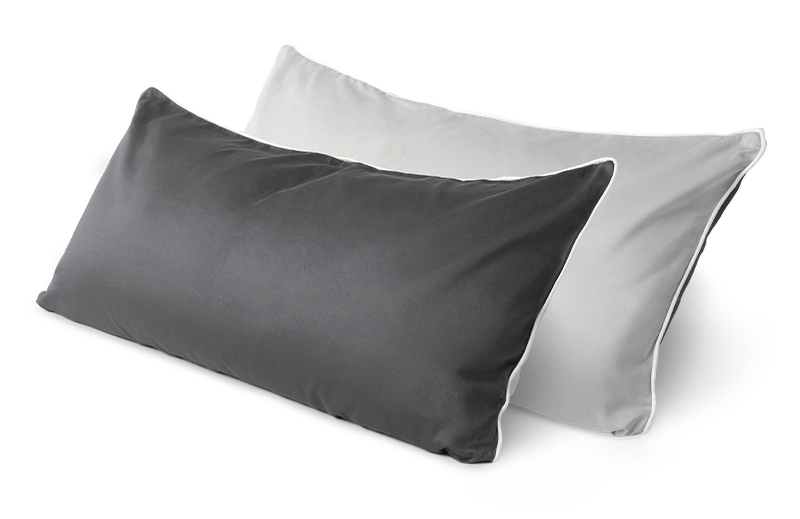 Dos almohadas: una blanca y una gris, dispuestas en ángulo.
