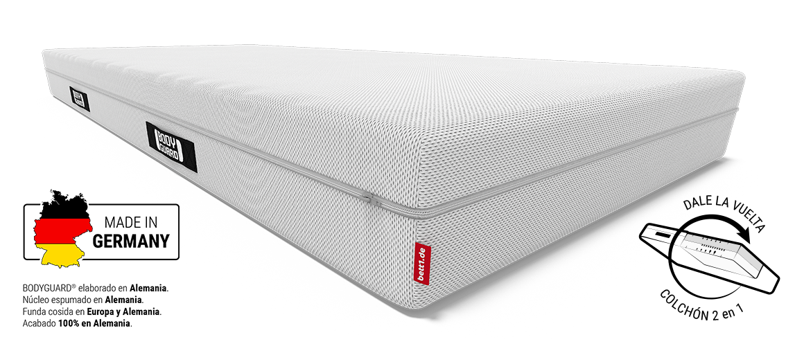 Colchón BODYGUARD® en vista diagonal con funda blanca, etiqueta roja de la marca, y una pequeña bandera de Alemania indicando fabricación nacional.