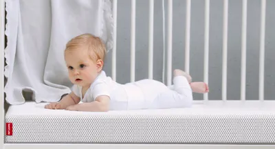 El bebé está tumbado sobre un colchón infantil